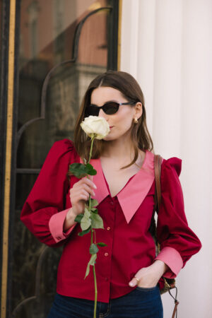 Czerwona koszula damska z bufkami i różowym kołnierzem oraz mankietami w połączeniu z jeansami